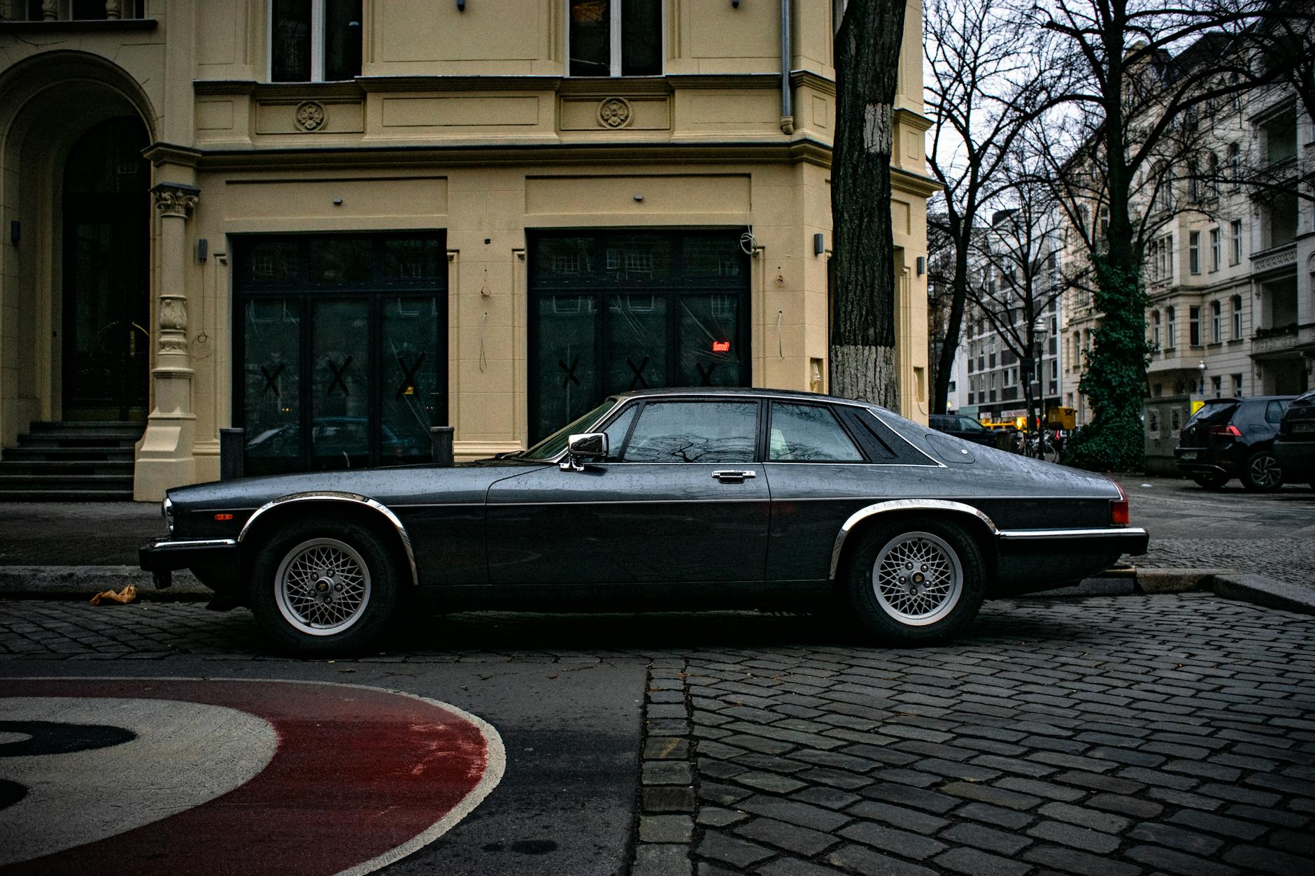 Vintage Jaguar vehicle parked on an urban street, showcasing classic design and elegance.