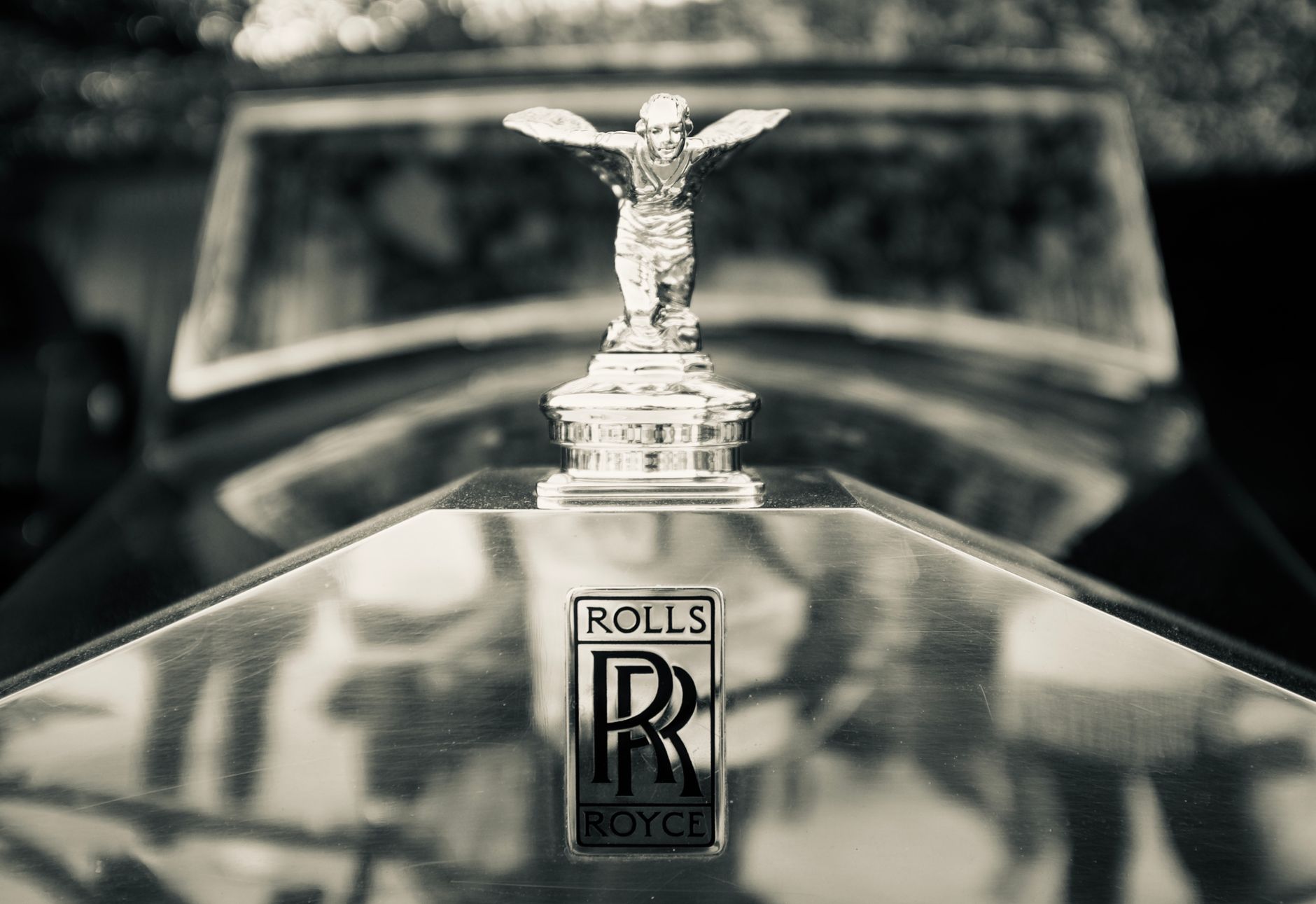 Elegant close-up of a Rolls Royce hood ornament, highlighting luxury and craftsmanship.