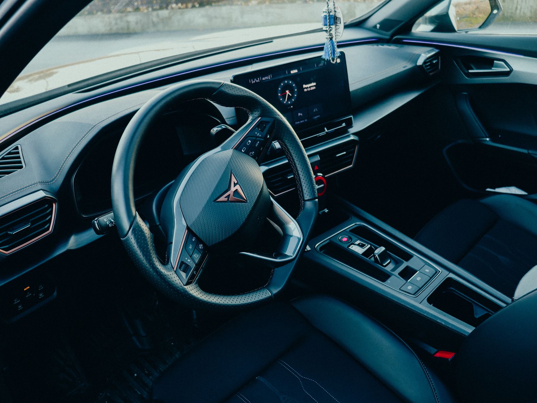 High-angle view of a modern car interior featuring a sleek dashboard and steering wheel.